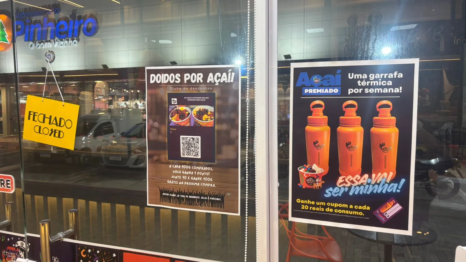 Store front showing the loyalty poster and the weekly water bottle raffle promotion